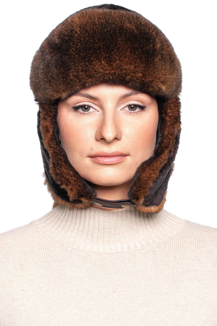 Model wearing a luxurious brown lamb and rex rabbit fur trapper hat for winter style and warmth.