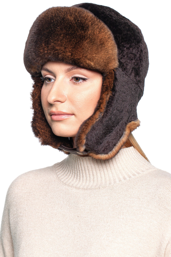 Model wearing a luxurious brown lamb and rex rabbit fur trapper hat for warmth and style in winter.