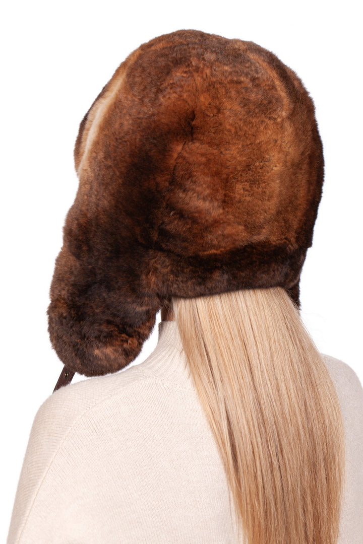 a woman wearing a brown rex rabbit fur hat with long blonde hair from the back