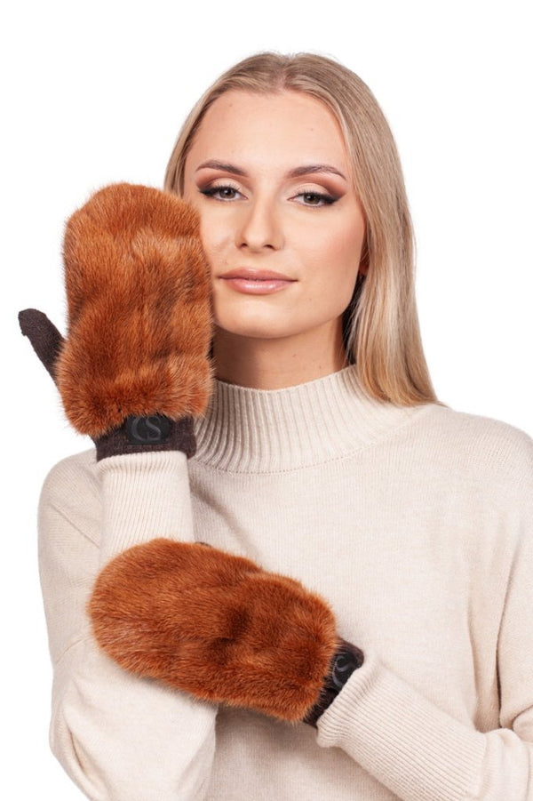 A person adorned in a cream-colored sweater gracefully poses with two exquisite FurbySD Rust Brown Mink Fur Mittens. One mitten softly conceals part of their face, while the other rests elegantly on their arm against the pristine white backdrop.