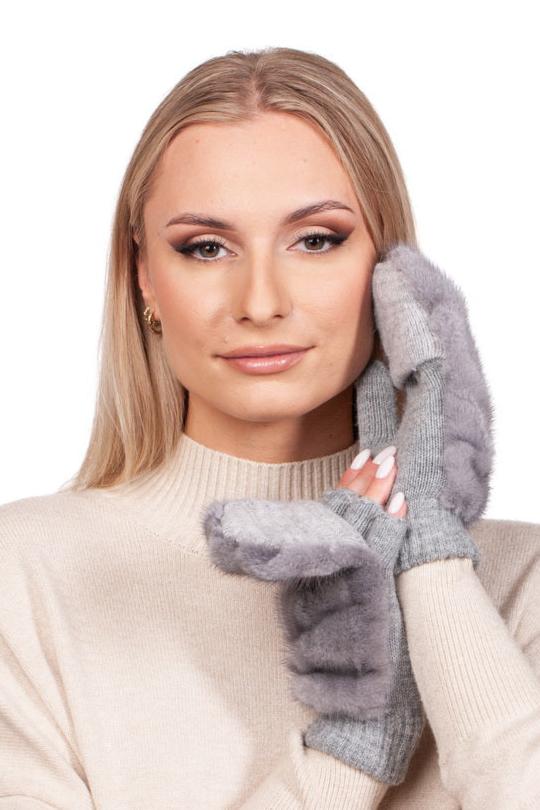 A blonde woman wearing a cream sweater poses with the Sapphire Mink Fur Flip Top Mittens by FurbySD, gently touching her face. The plain white background emphasizes her serene expression and the luxurious feel of the mittens.