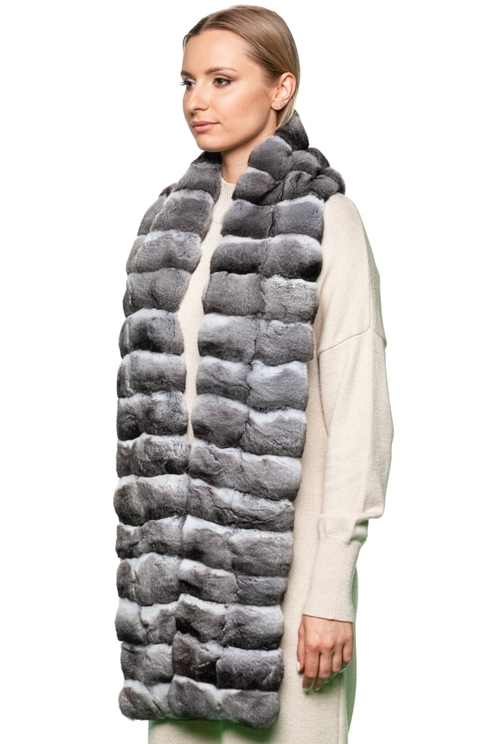 Three-quarter angle – luxury chinchilla fur scarf in soft grey tones styled over cream knit dress, long handmade winter fashion piece.