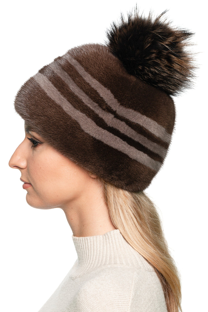 Close-up side view of striped mink fur beanie in brown tones with fox pom pom, soft real fur winter hat handmade by FurbySD
