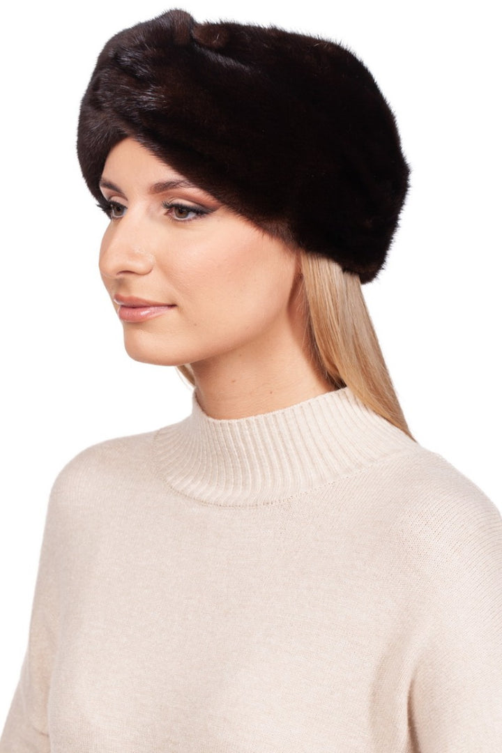 A person with long blonde hair is sporting the Dark Brown Mink Fur Headband by FurbySD, paired with a light-colored turtleneck sweater that elegantly highlights the luxurious cashmere lining beneath. The background is white.