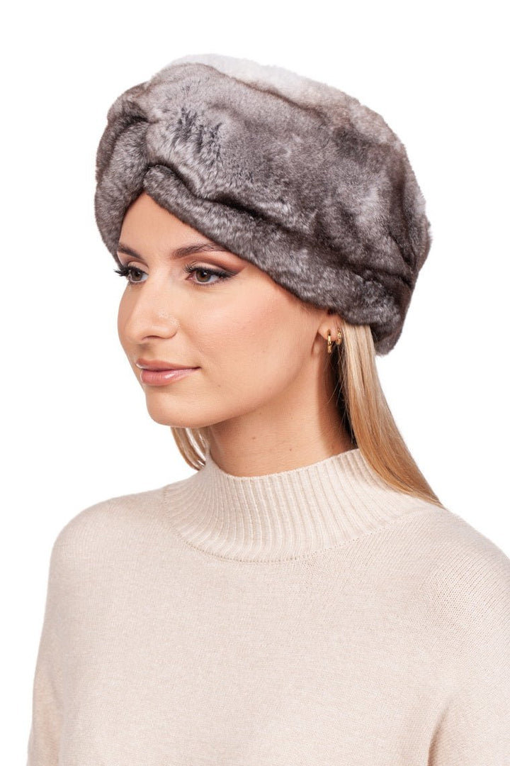 A woman wearing a fuzzy gray Grey Rex Rabbit Fur Headband by FurbySD and a cream sweater. She has long, light brown hair and gold hoop earrings. A chic winter accessory choice, she gazes to the side against a plain white background.