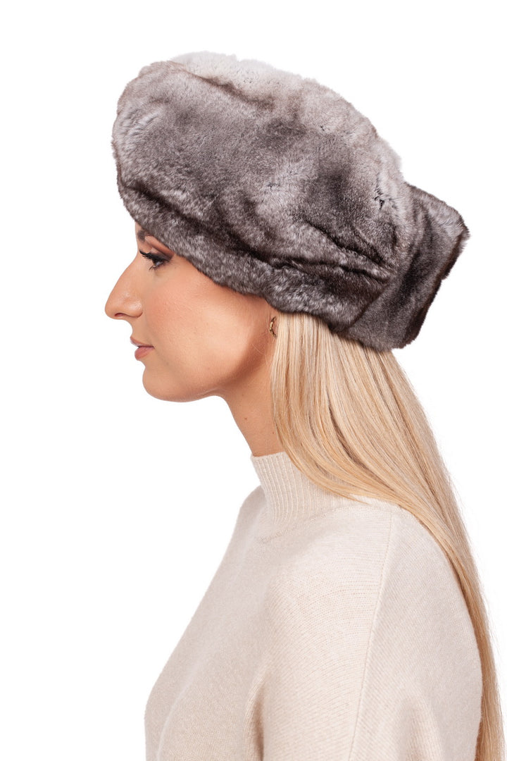 A person with long blonde hair wears a gray fur hat featuring the Grey Rex Rabbit Fur Headband by FurbySD and a cream-colored sweater, looking to the left against a plain white background.