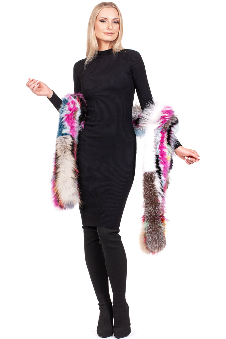 A woman in a black fitted dress poses confidently, adorned with FurbySD's Long Knitted Fox Fur Scarf, displaying its vibrant multicolor design. She completes her look with black knee-high boots while standing against a white background.