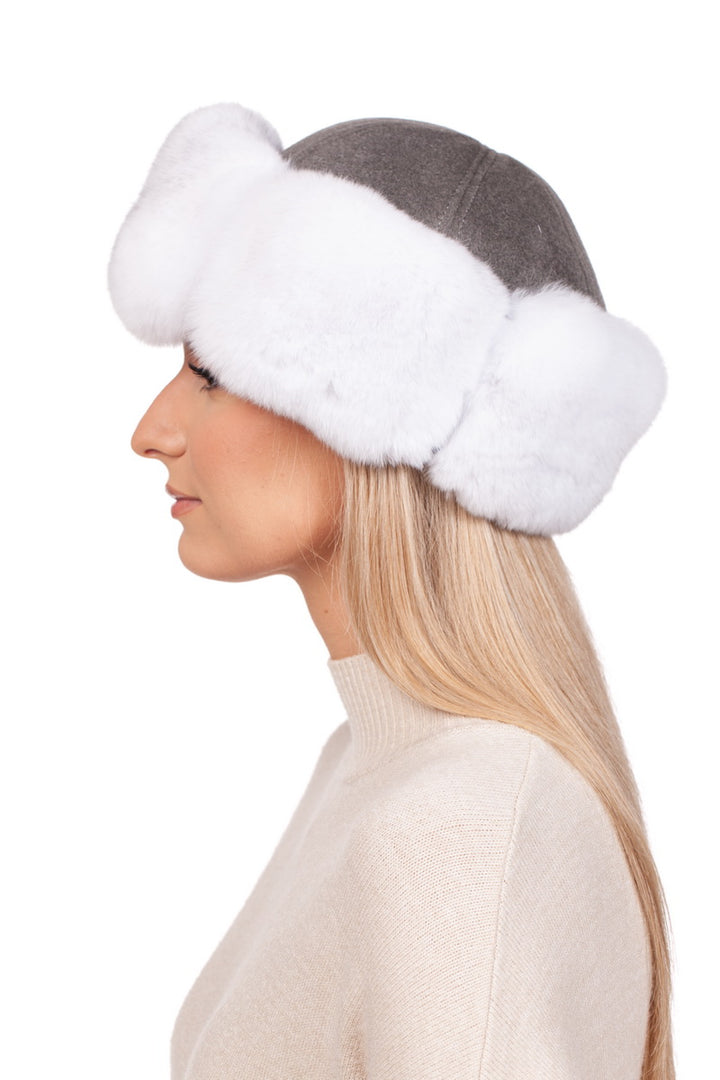 Side profile of a woman with long, straight blonde hair wearing a beige sweater and the FurbySD White Chinchilla Fur Roller Hat, featuring a wide, fluffy white chinchilla fur brim. The background is white.