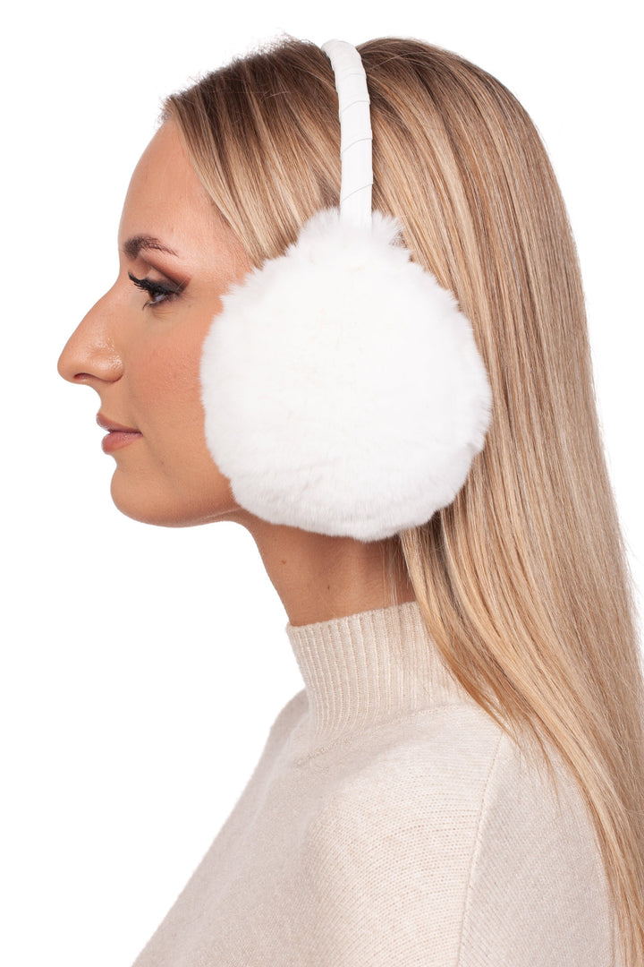 A person with long blonde hair is shown in profile, wearing FurbySD's White Rex Rabbit Fur Earmuffs and a beige sweater, against a white background.