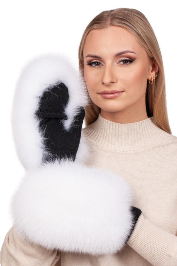 A woman with long blonde hair elegantly showcases the FurbySD White Fox Fur Flip Top Mittens while wearing a beige turtleneck sweater. With her subtle makeup and small hoop earrings, she poses against a white backdrop, drawing attention to the black mittens' chic fox fur trim.