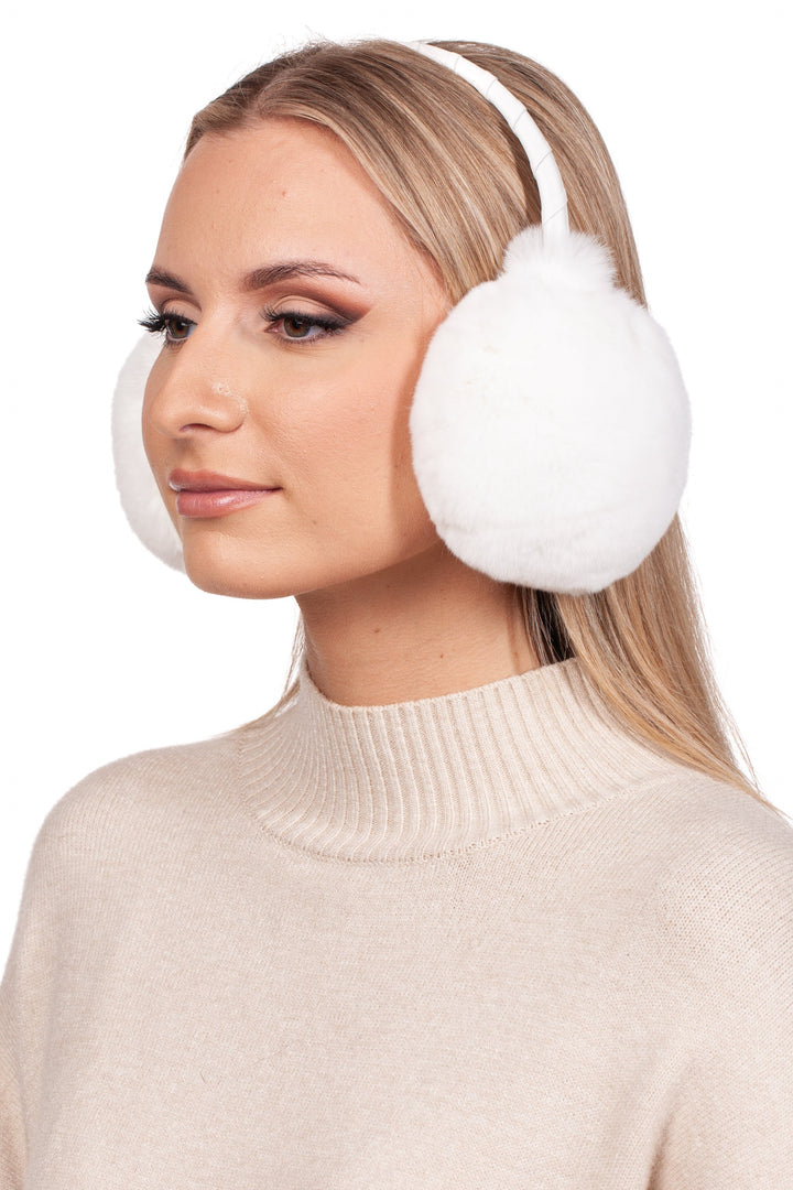 A person with long blonde hair is wearing FurbySD's luxurious White Rex Rabbit Fur Earmuffs and a beige turtleneck sweater, gazing to the side against a plain white background.