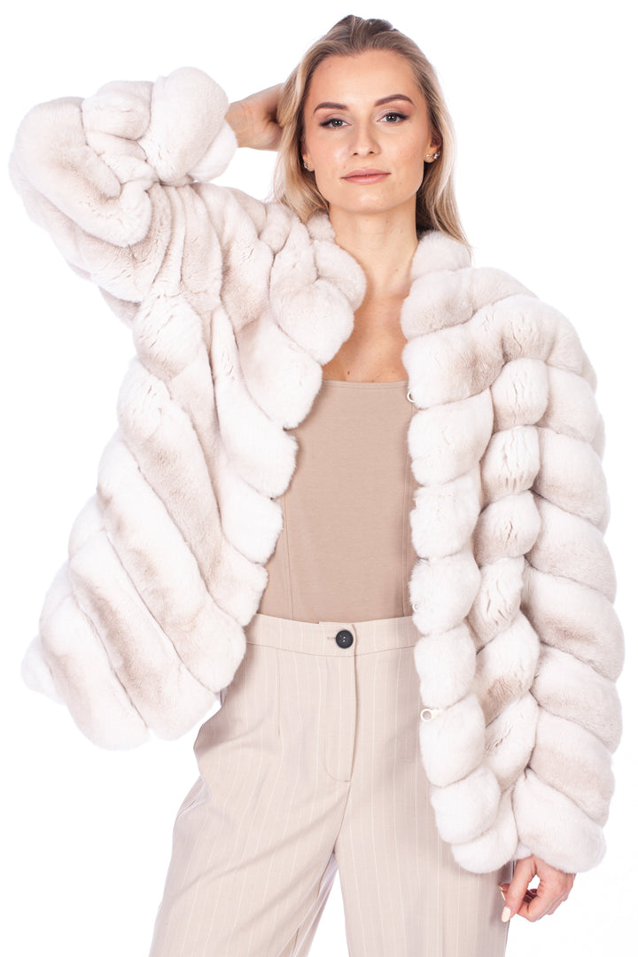 A person with long hair is wearing a luxurious Cream Chinchilla Fur Coat by FurbySD and beige pants, posing with one hand raised to their head against a plain white background.