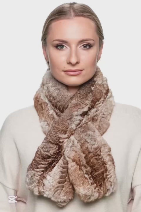 Woman wearing a brown chinchilla fur knitted scarf around her neck, shown from the side, paired with a beige sweater on a white background.