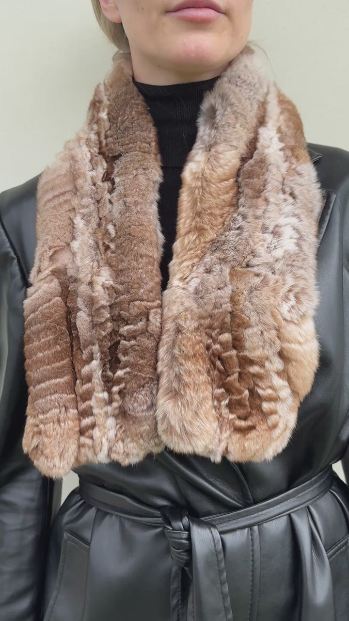 Front view of a model wearing a luxurious brown chinchilla fur knitted scarf draped loosely over the shoulders, soft and voluminous texture visible.