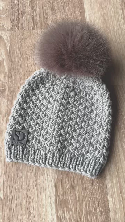 Grey Merino Wool Beanie With Beige Fox Fur Pom Pom On The Wooden Floor.