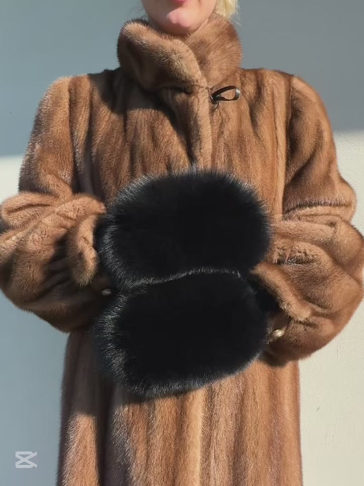 Woman wearing handmade black fox fur flip top mittens, convertible winter gloves with real SAGA-certified fox fur trim and merino wool knit, luxury cold weather accessory.