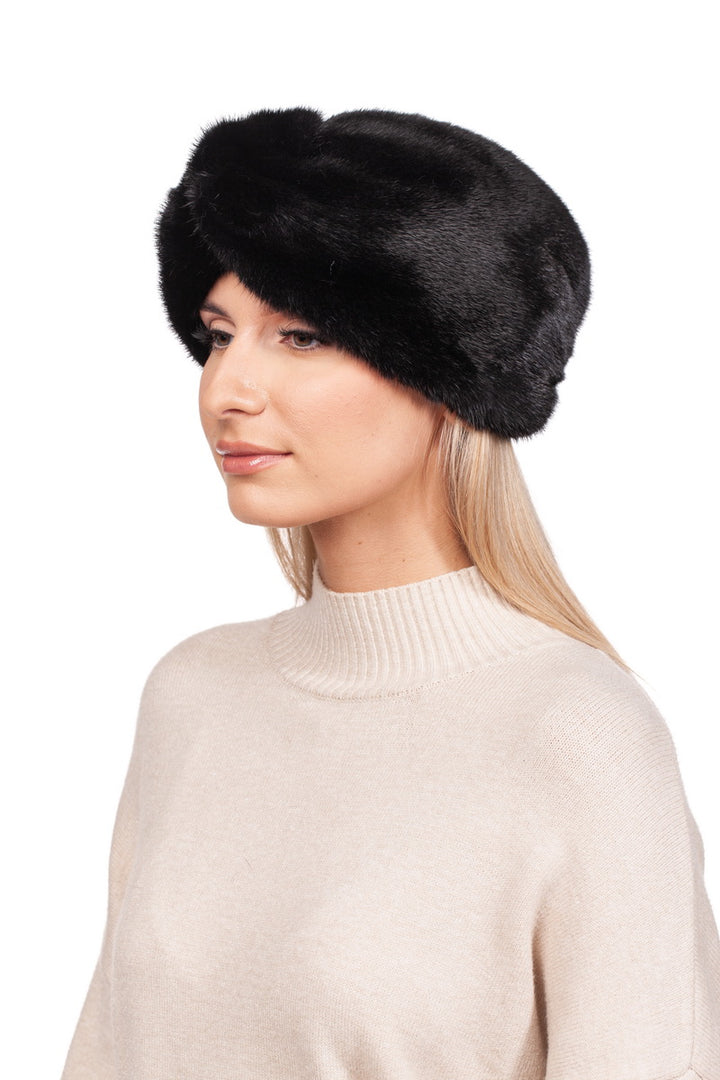 A woman gazes to the side, wearing a cream-colored sweater and a luxurious FurbySD Black Mink Fur Headband.