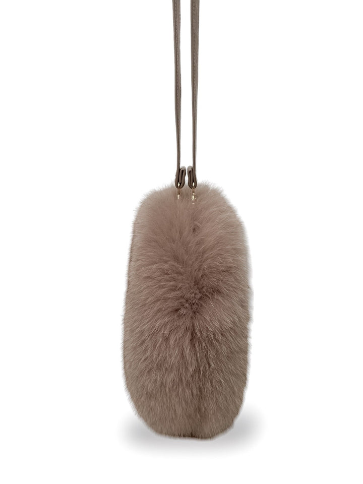 Introducing the FurbySD Beige Fox Fur Clutch, a beige, oval-shaped handbag with a long strap perfect for wearing over the shoulder or crossbody. This stylish accessory boasts a plush, soft texture that exudes coziness and luxury, making it an ideal addition to any wardrobe.