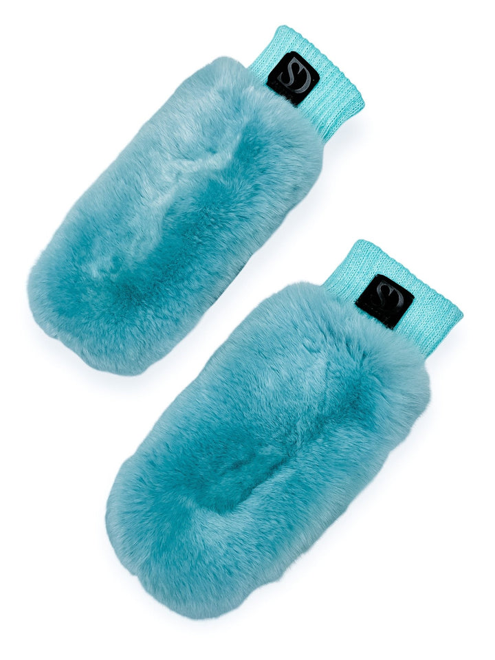 Displayed on a white background, the Chinchilla Fur And Leather Mittens in Blue by FurbySD are a luxurious pair of handmade, fluffy turquoise mittens with knit cuffs. Each mitten is adorned with a black label featuring the logo on the cuff. Ethically sourced chinchilla fur contributes to their cozy elegance, and they are crafted with care in Lithuania.